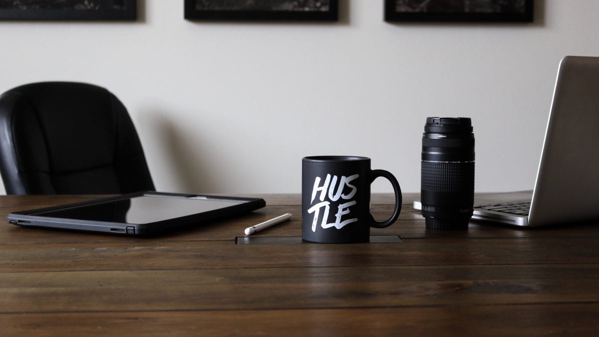 hustle mug sitting on a table with work supplies