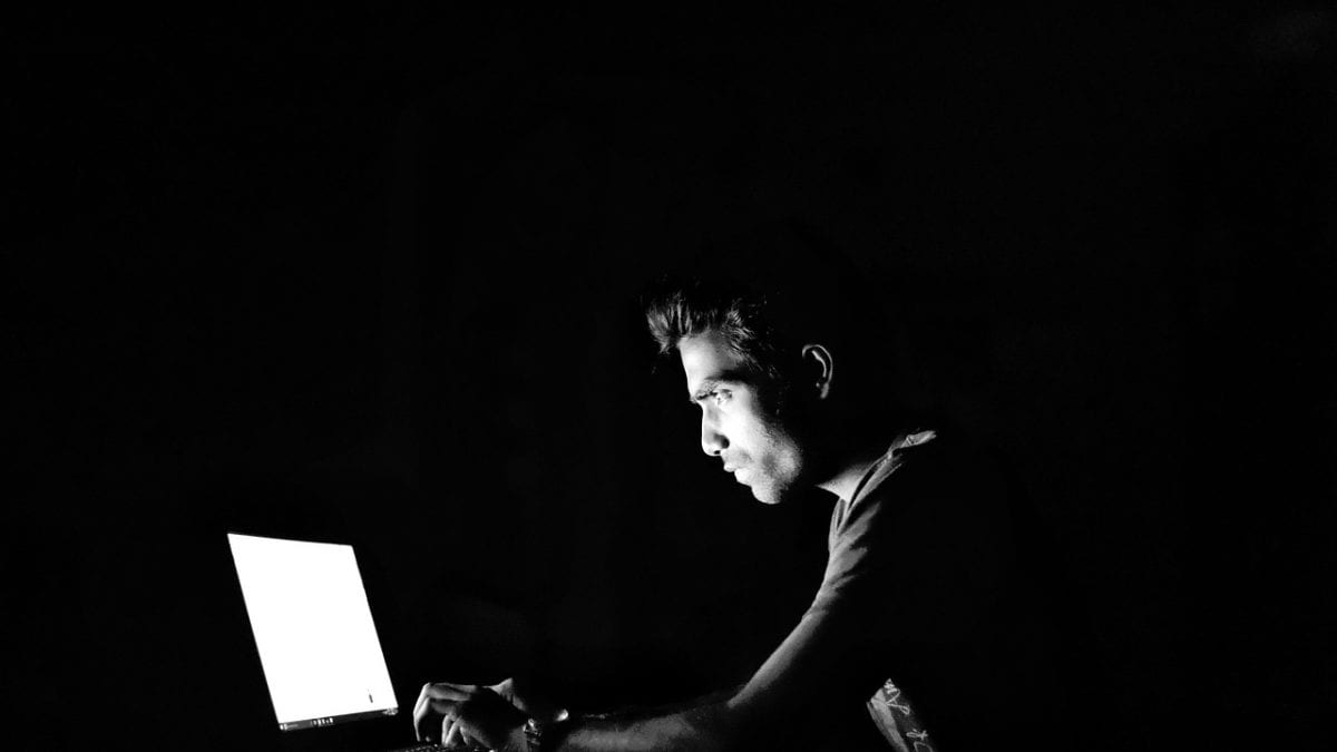 Man working on computer in the dark