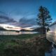 airstream by a river with a beautiful sunset