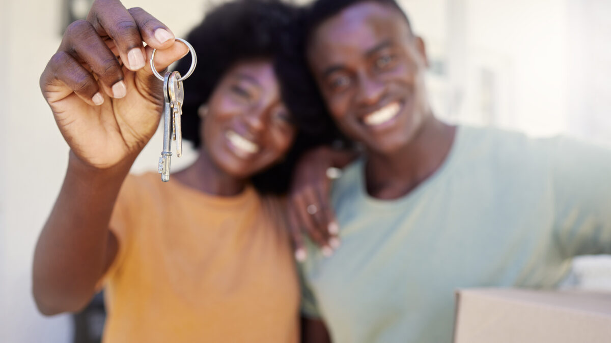 Two people smiling holding the key
