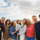 Group of multigenerational friends smiling in front of camera -