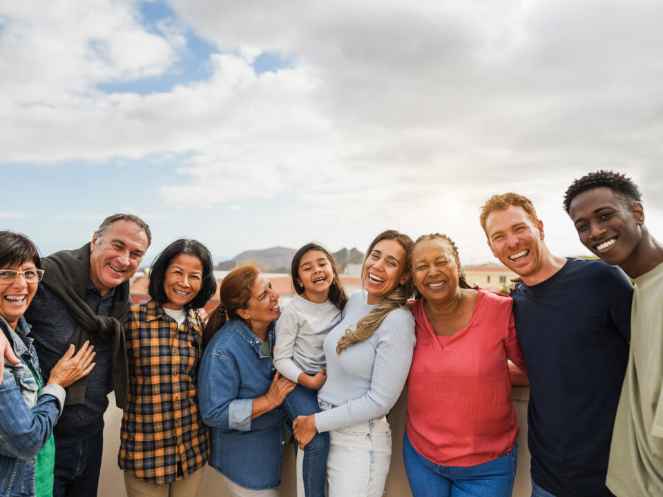 Group of multigenerational friends smiling in front of camera -