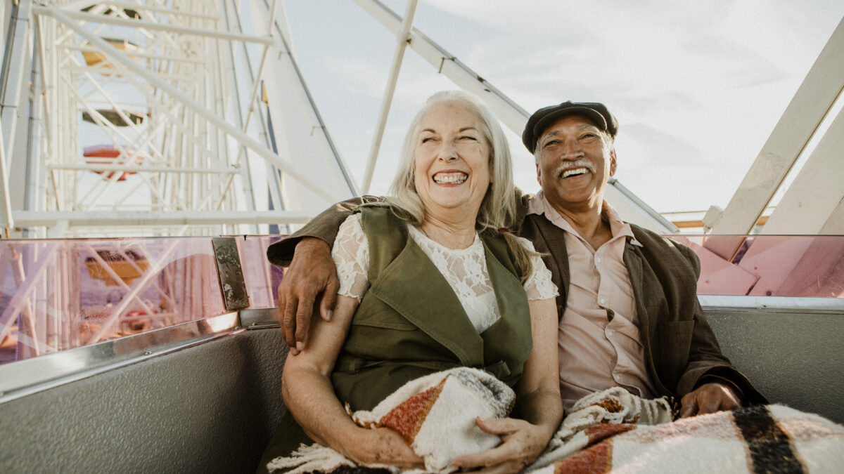 Cheerful senior couple enjoying a Ferris wheel by the Santa Monica pier