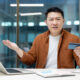 Money transfer blocking and fraud. Upset and disappointed asian man looking at camera while holding bank credit card, account access denied and error.