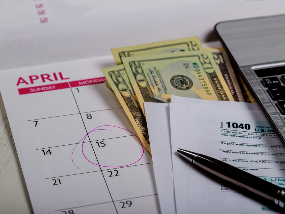 1040 US tax form, money and calendar with U.S dollars money and computer keyboard