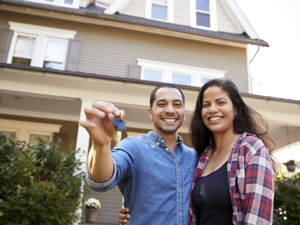 Portrait Of Couple Holding Keys To New Home On Moving In Day