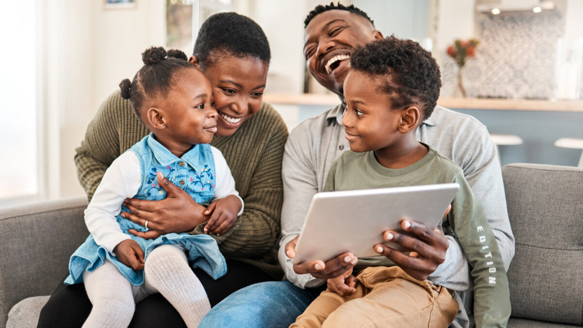 Shot of a happy young family using a digital tablet on the sofa at home.