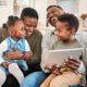 Shot of a happy young family using a digital tablet on the sofa at home.