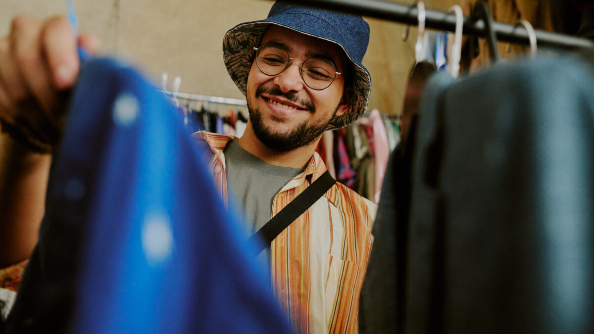 Smiling Man Shopping for Clothing in Thrift Store