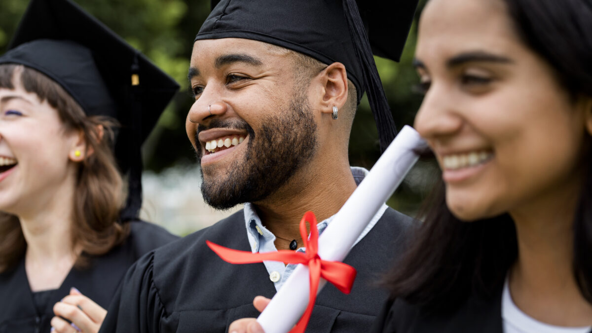 Happy diverse students graduating university, celebrating with d