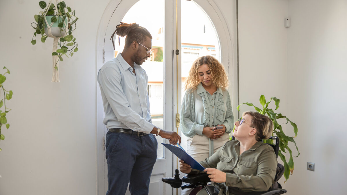 Couple caring for a disabled woman in wheelchair.